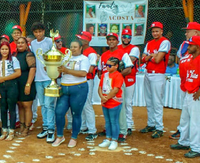 La seu00f1ora Nana Checo, exhibe la copa ganada por el equipo de softbol del club Ariel Acosta